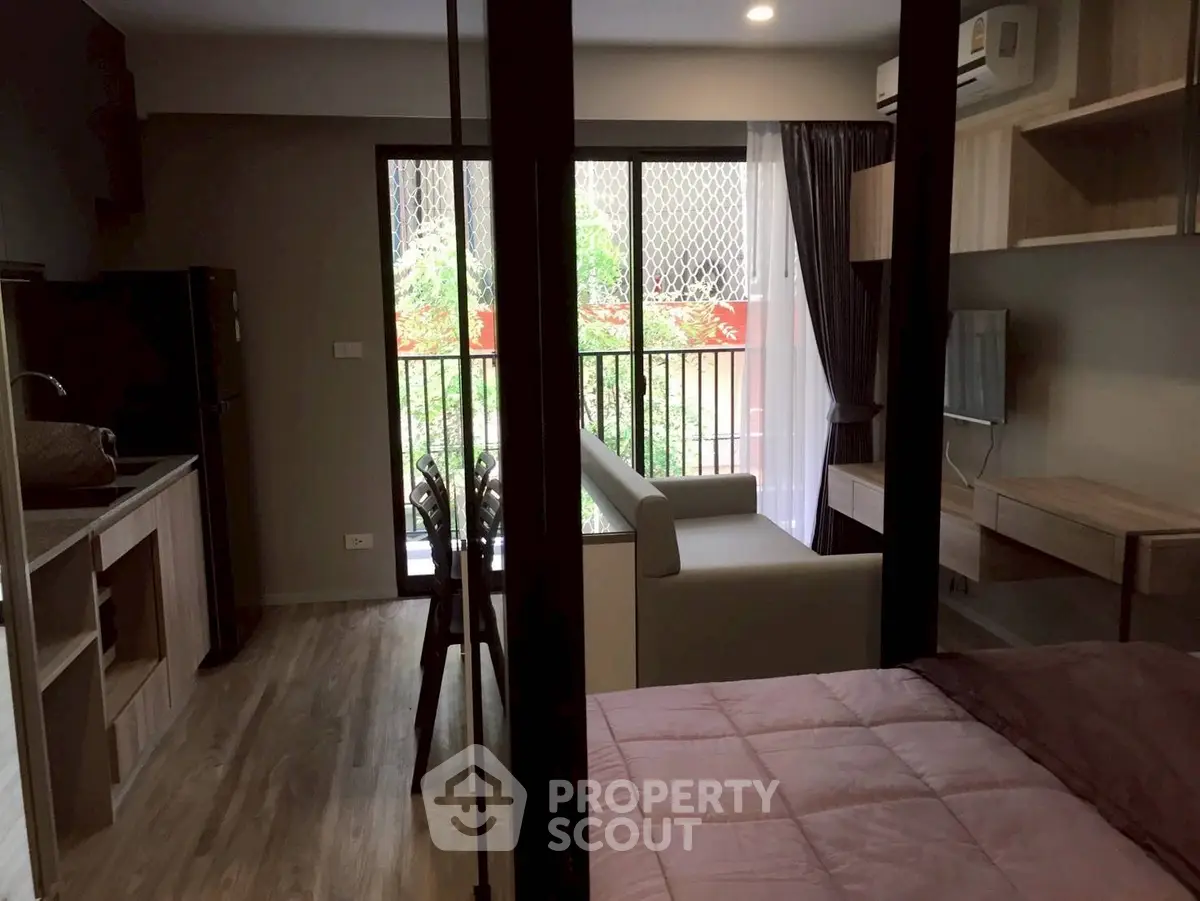 Modern studio apartment with balcony, open layout, and stylish furnishings.