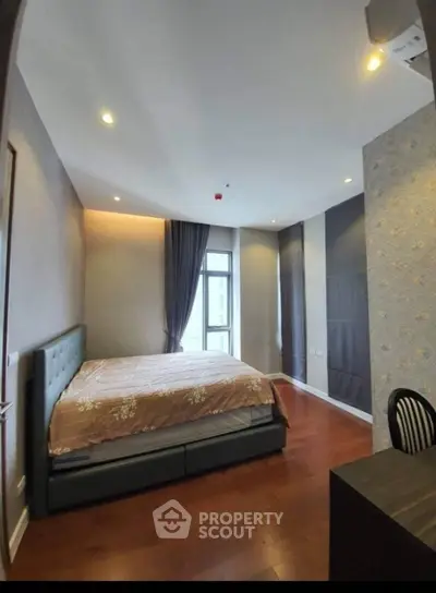 Spacious bedroom with modern decor and large window offering natural light.