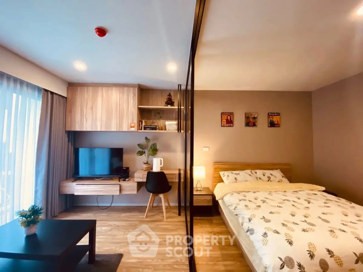 Modern bedroom with stylish decor and workspace, featuring a cozy bed and natural light.