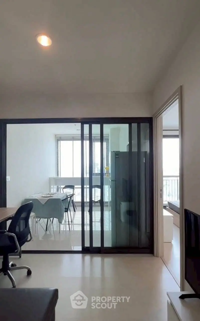 Modern apartment interior with sliding glass doors and dining area, featuring a bright and airy ambiance.