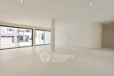 Spacious open-plan interior with large windows and modern lighting