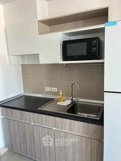 Modern kitchen with sleek cabinetry and built-in microwave