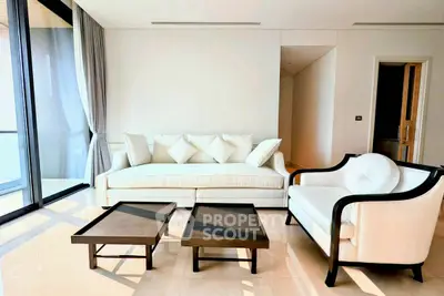 Elegant living room with modern furniture and large windows offering natural light.