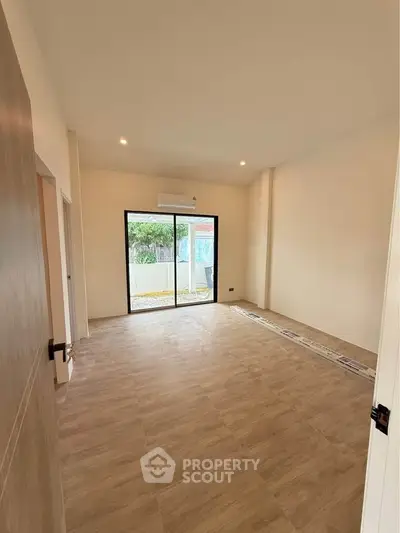 Spacious unfurnished room with large window and air conditioning unit