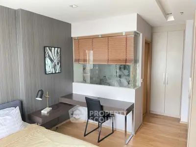 Modern bedroom with study area, featuring sleek desk and chair, stylish decor, and ample natural light.