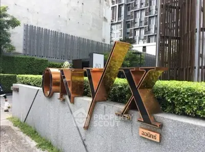 Modern building exterior with stylish ONYX sign and lush greenery, showcasing urban living elegance.