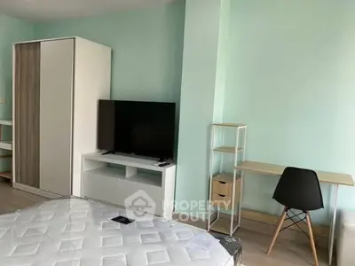 Modern bedroom with minimalist furniture and a sleek TV setup.