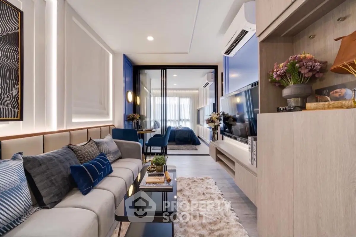 Modern living room with stylish decor and open layout leading to bedroom