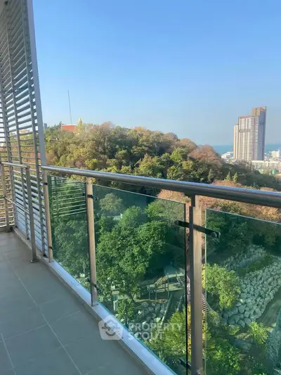 Stunning balcony view overlooking lush greenery and cityscape, perfect for relaxation.