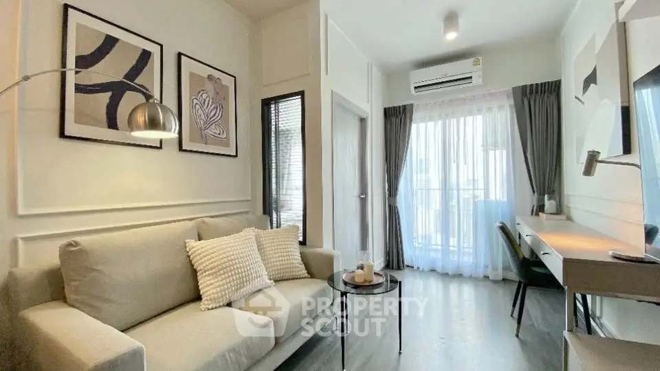 Modern living room with stylish decor and natural light, featuring a cozy sofa and work desk.