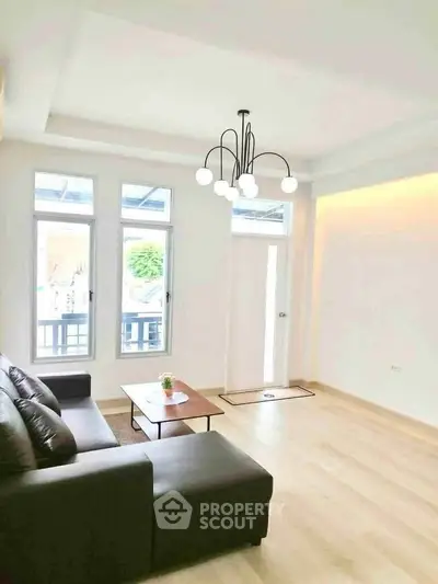 Bright and spacious living room with modern lighting and comfortable seating.