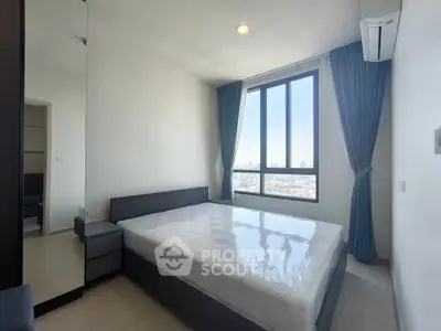 Modern bedroom with large window and city view, featuring a sleek design and ample natural light.