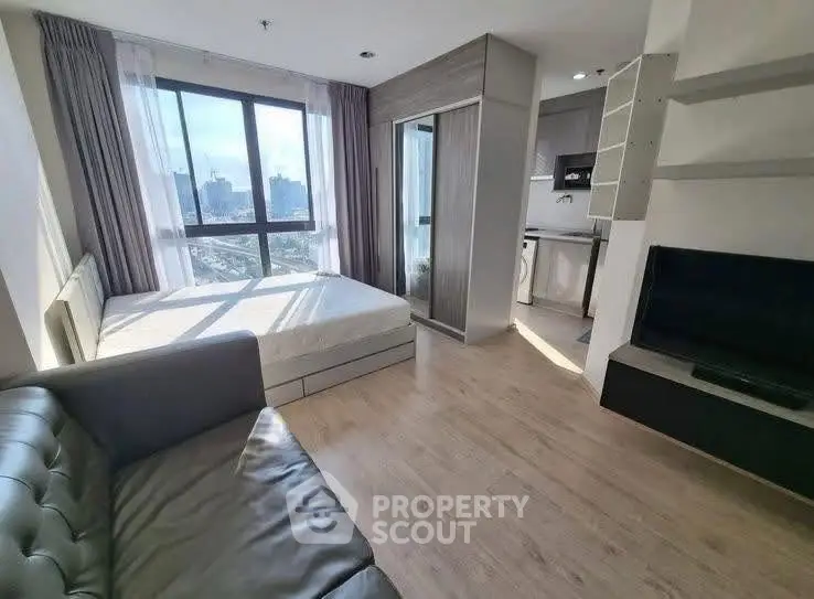 Modern studio apartment with large window and sleek furnishings