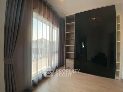Spacious bedroom with large window and modern built-in wardrobe
