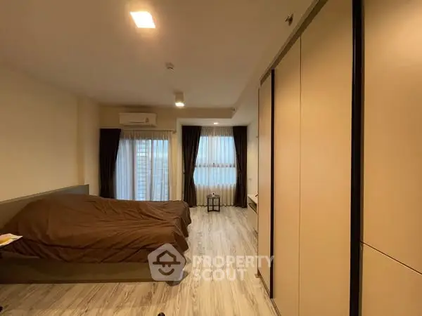 Spacious bedroom with modern design and large windows for natural light.