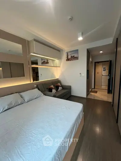 Modern bedroom with stylish decor and cozy seating area in a contemporary apartment.