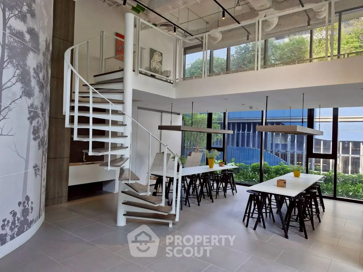 Modern open-plan living space with spiral staircase and large windows