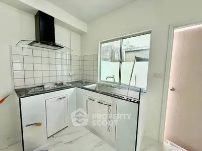 Modern kitchen with sleek design, featuring a gas stove and ample natural light.