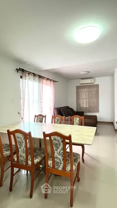 Spacious living room with elegant dining area and cozy seating, perfect for family gatherings.