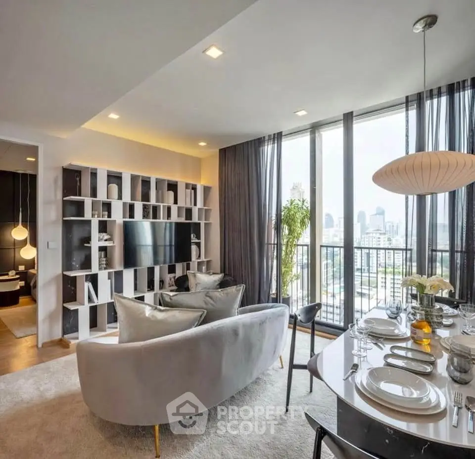 Luxurious modern living room with city view, elegant decor, and spacious balcony access.