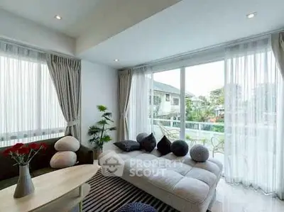 Bright and airy living room with modern furniture and large windows overlooking a lush garden.
