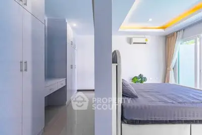 Spacious modern bedroom with built-in storage and large windows for natural light.