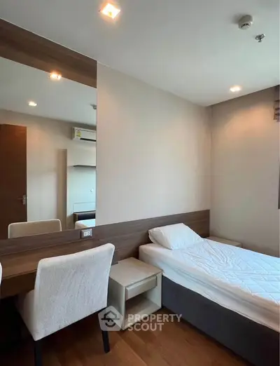 Cozy bedroom with modern furnishings and ample natural light, perfect for relaxation and comfort.