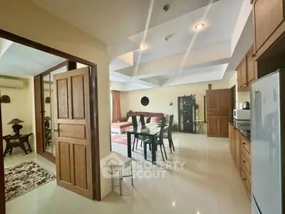Spacious open-layout living and dining area with modern kitchen in a stylish apartment.