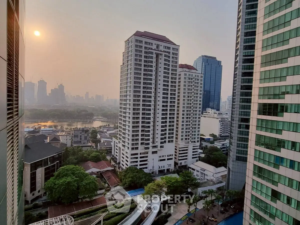 Stunning cityscape view from high-rise apartment balcony at sunset.