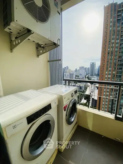 High-rise condo balcony with washer and dryer, city skyline view