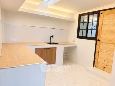Modern minimalist kitchen with wooden accents and sleek black faucet