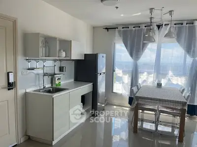 Bright kitchen with dining area, featuring modern appliances and large windows for natural light.