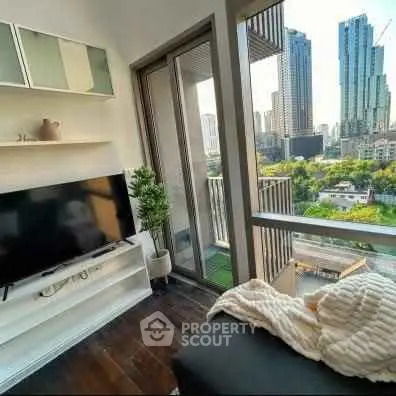 Modern living room with city view and balcony access in high-rise apartment.