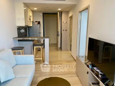 Modern open-layout living room with kitchen bar and cozy seating area in a stylish apartment.
