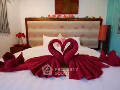 Luxurious bedroom with elegant swan towel art on a cozy bed, perfect for relaxation.