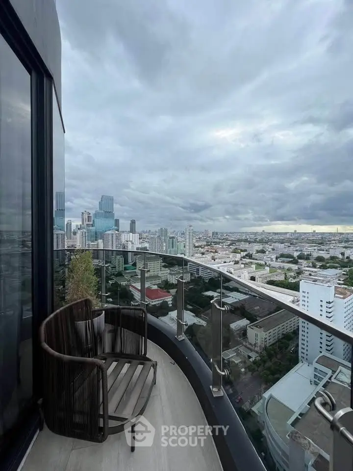 Stunning cityscape view from a modern high-rise balcony with sleek glass railing.