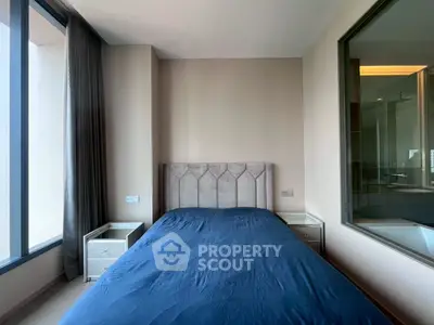 Modern bedroom with large window and stylish bed in a contemporary apartment.