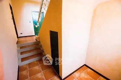 Charming interior staircase with warm terracotta tiles and elegant railing in a cozy home.