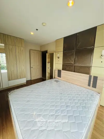 Spacious bedroom with modern design and ample natural light, featuring built-in wardrobes and a comfortable bed.