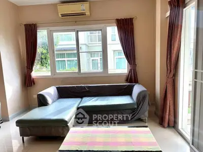 Spacious living room with large windows and L-shaped sofa, offering a bright and inviting atmosphere.