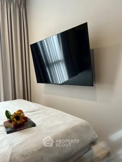 Modern bedroom with wall-mounted TV and cozy decor