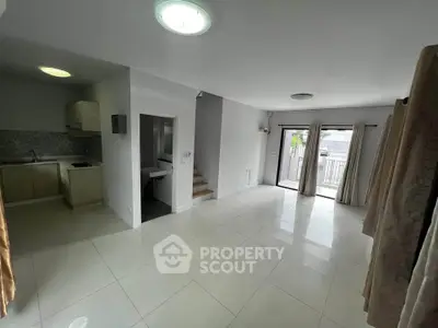Spacious open-plan living area with modern kitchen and balcony access