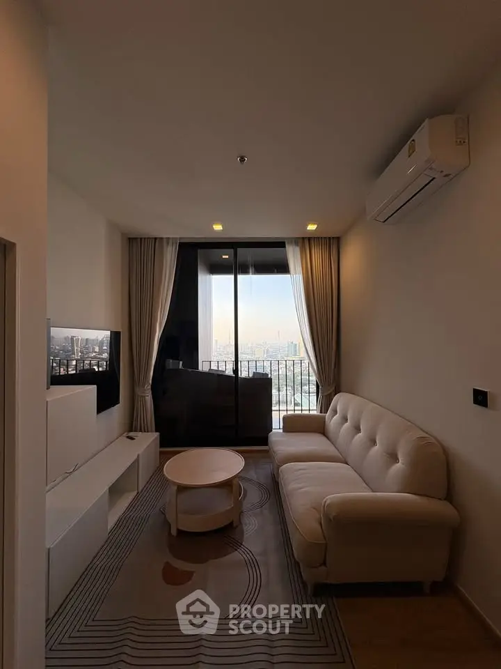 Modern living room with city view, featuring a cozy sofa and sleek entertainment unit.