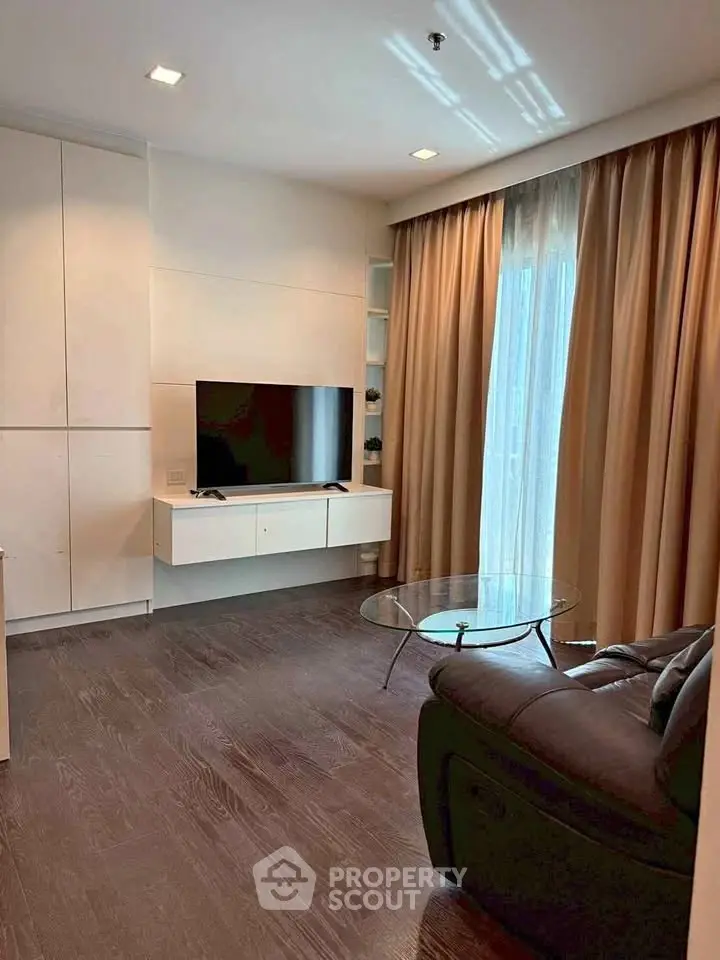 Modern living room with sleek TV setup and cozy seating area.