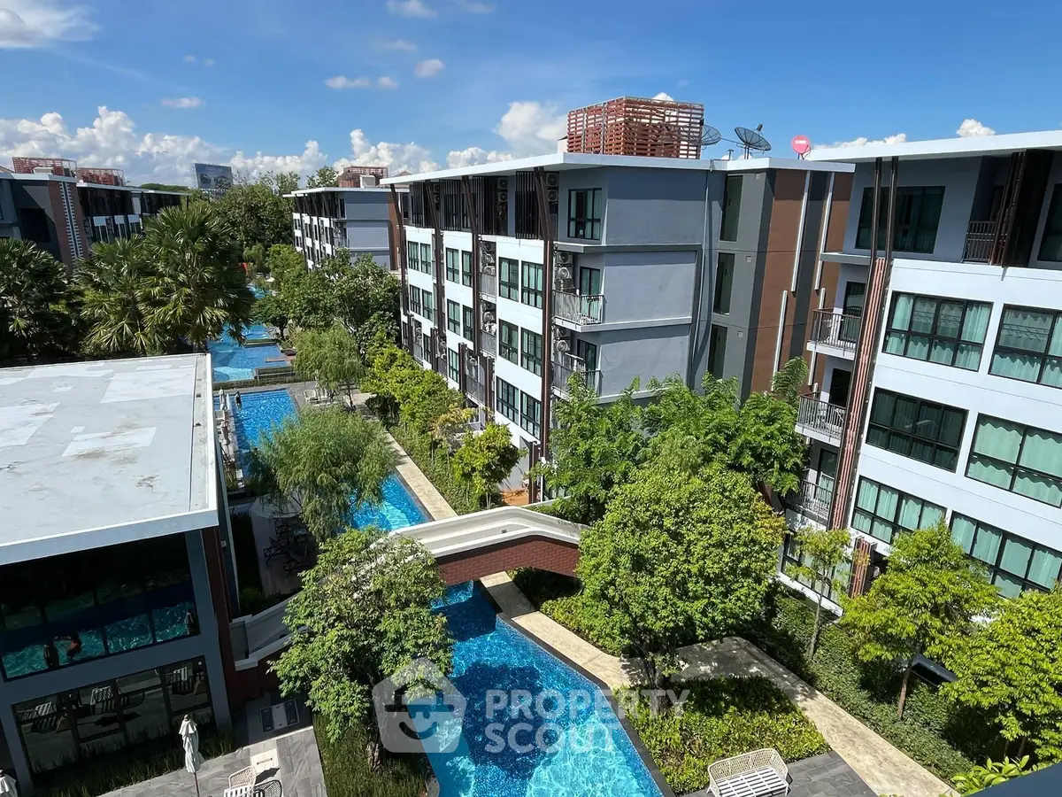 Luxurious condominium complex with lush greenery and stunning pool view