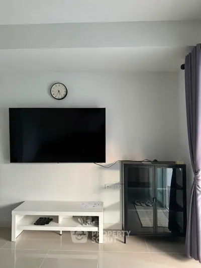 Modern living room with wall-mounted TV and sleek furniture