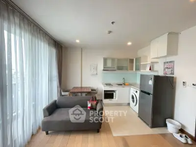 Modern open-layout living room with kitchen, featuring a cozy sofa and dining area, perfect for urban living.
