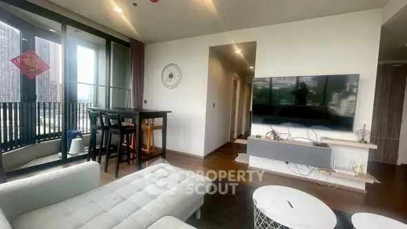 Modern living room with large TV and balcony view in upscale apartment