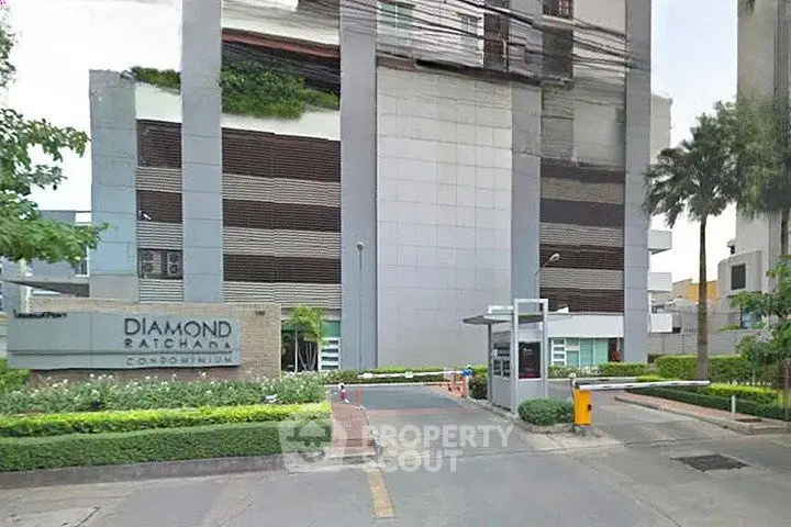 Modern condominium entrance with sleek design and lush landscaping at Diamond Ratchada.