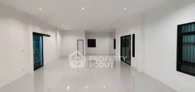 Spacious modern interior with sleek white walls and glossy floors, perfect for versatile living or office space.